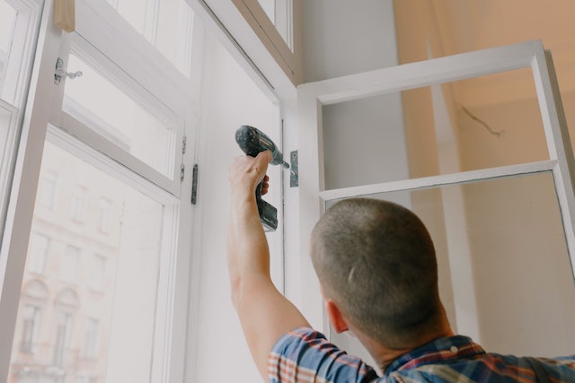 Person using a drill to fix a window