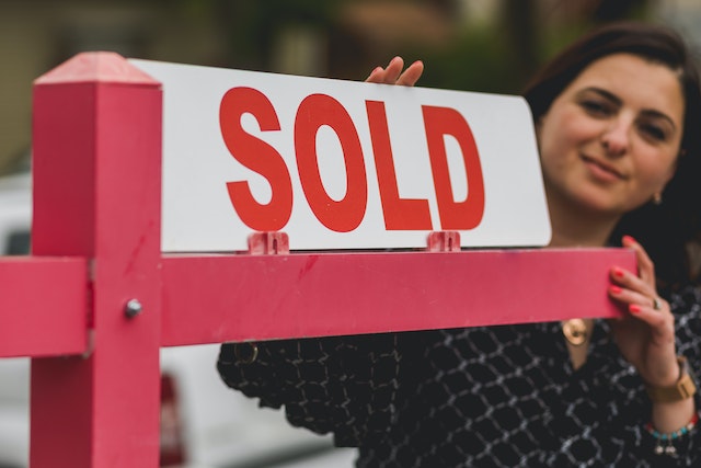 Person placing a sold sign