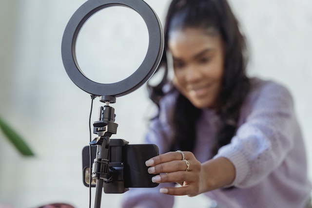 person-setting-up-a-phone-and-ring-light-on-a-tripod